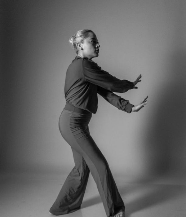 Woman performing a fluid cardio movement in a calm studio.
